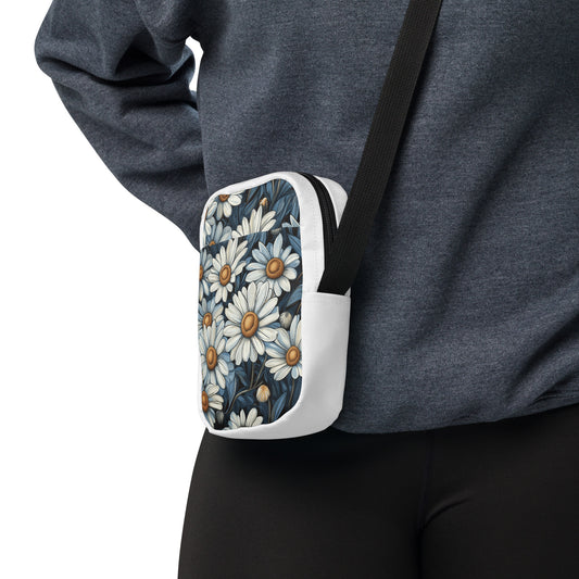 A person wearing a white utility crossbody bag with a blue and white daisy floral pattern.