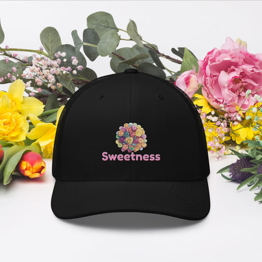 Black cap with 'Sweetness' text and a graphic of colourful candies on a floral background.
