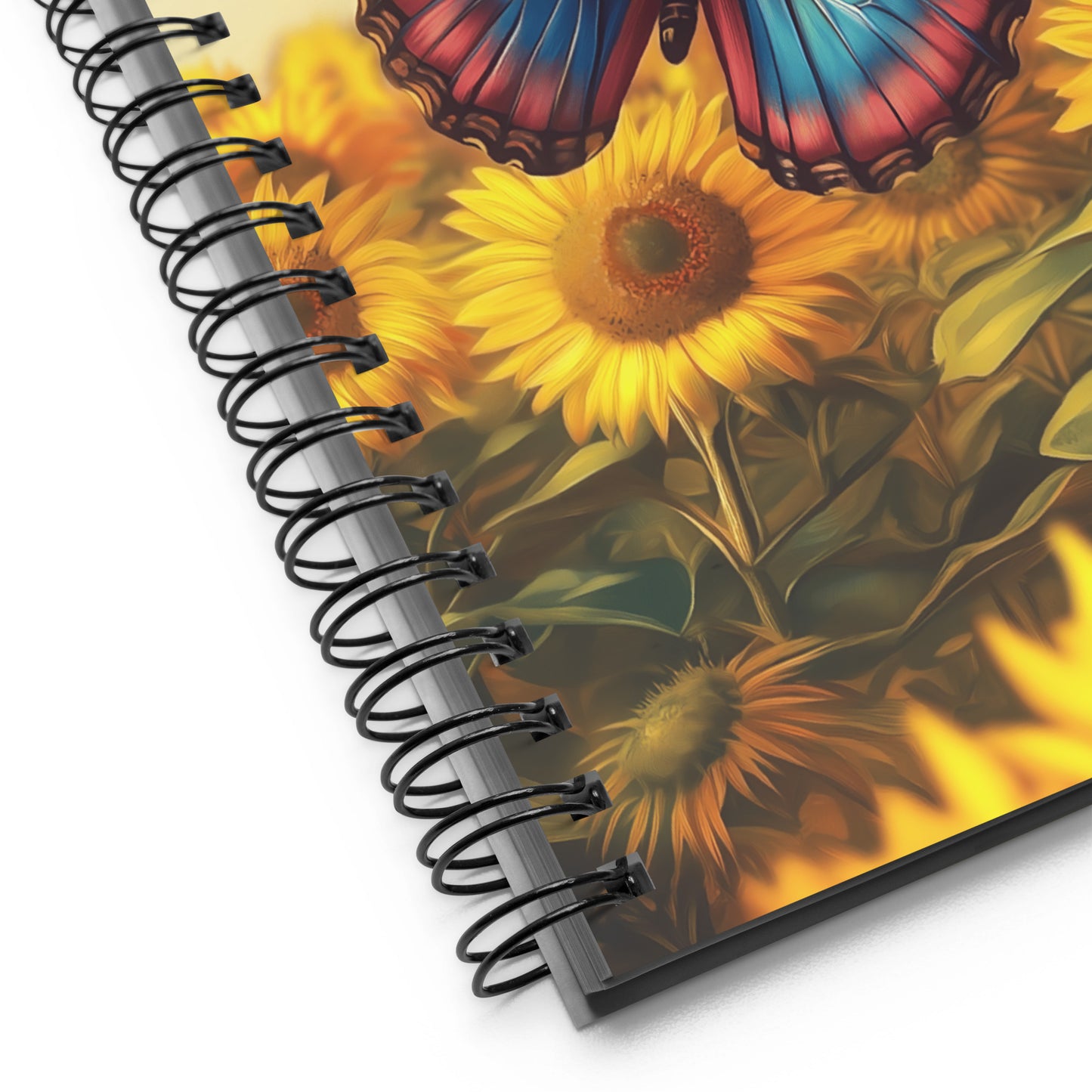 Detail of a spiral notebook with a butterfly and sunflower design on the cover.