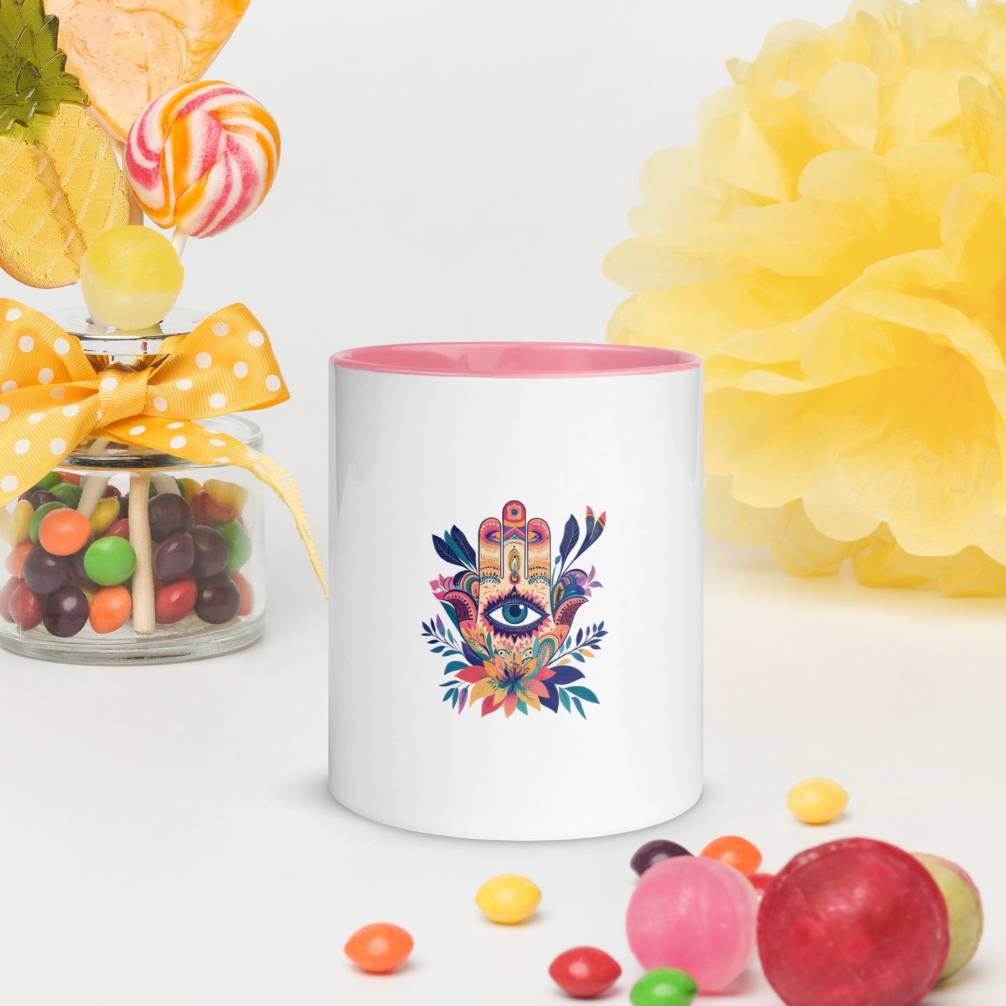 White ceramic mug with pink handle and interior featuring a colorful Hamsa hand art print.