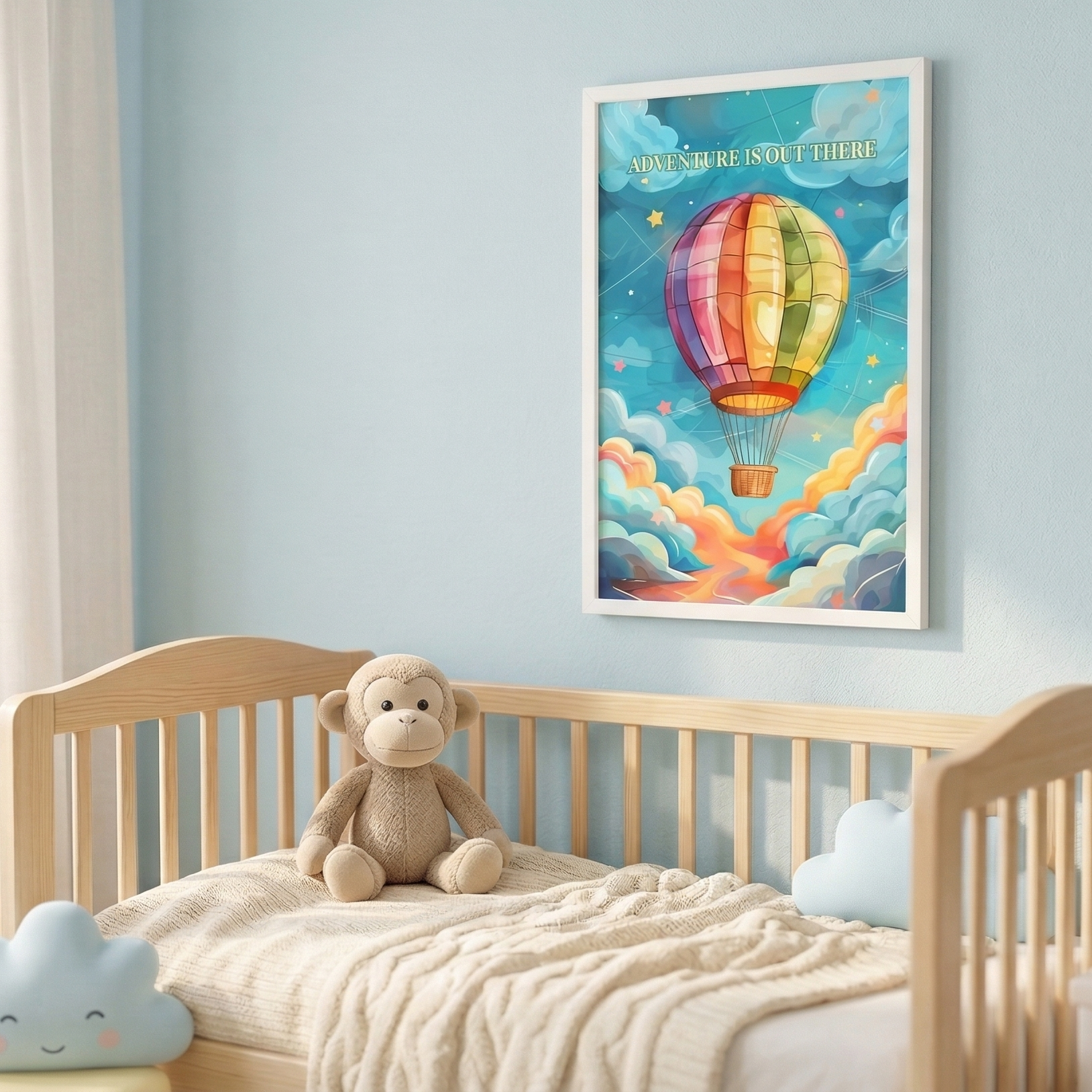 Lifestyle mockup of a framed 'Adventure is out there' hot air balloon poster in a bright, modern nursery. The white-framed poster is hung over a wooden crib with linen curtains, a knitted pouf, and a plush monkey toy, all bathed in soft natural light.