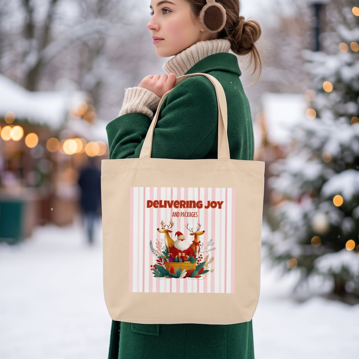 A woman in a green coat and brown earmuffs carries a beige canvas tote bag with a festive Christmas graphic that reads 'DELIVERING JOY AND PACKAGES'. The background is a blurred snowy outdoor holiday market scene.