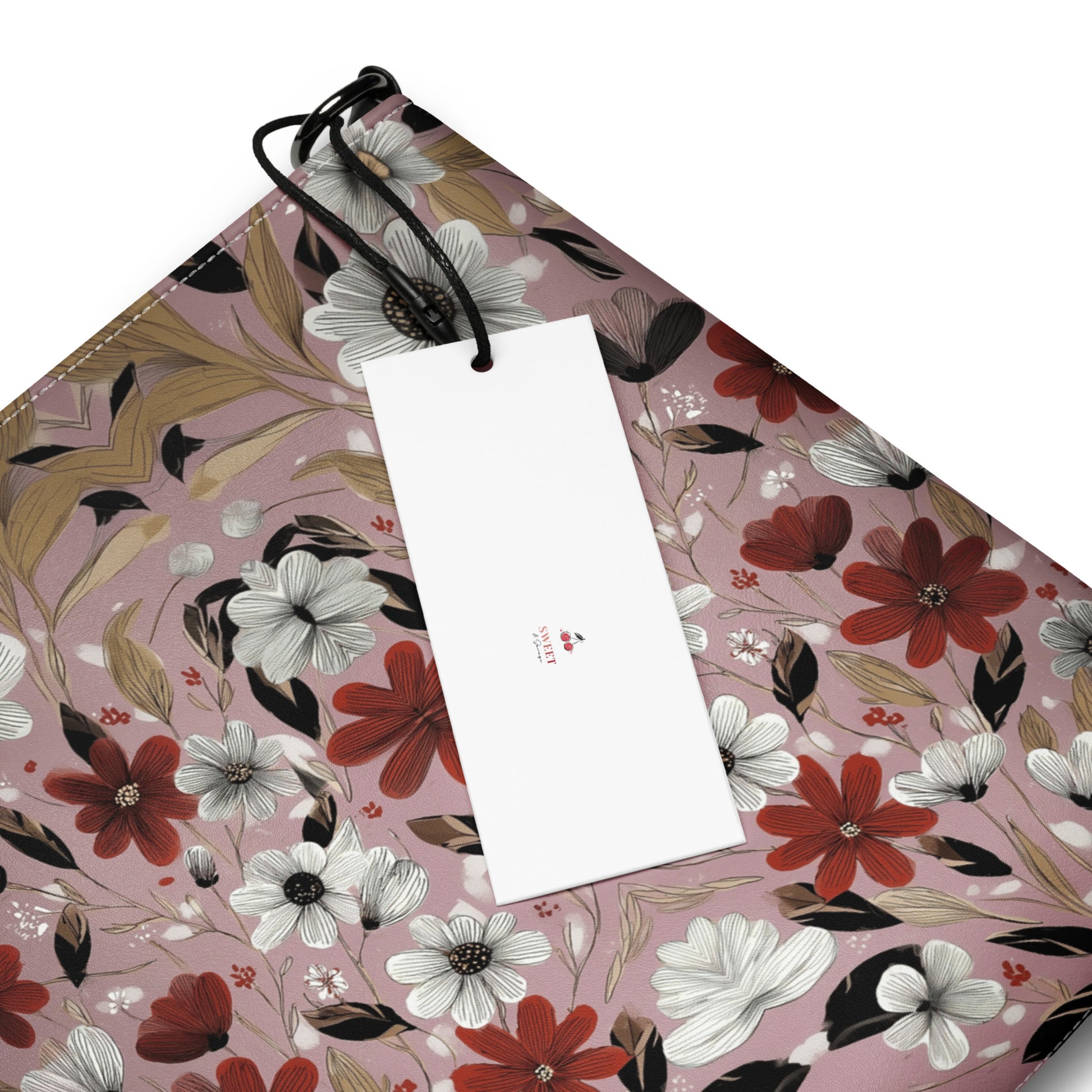 A white crossbody bag featuring a pink and black "Bloom Your Own Way" floral pattern.