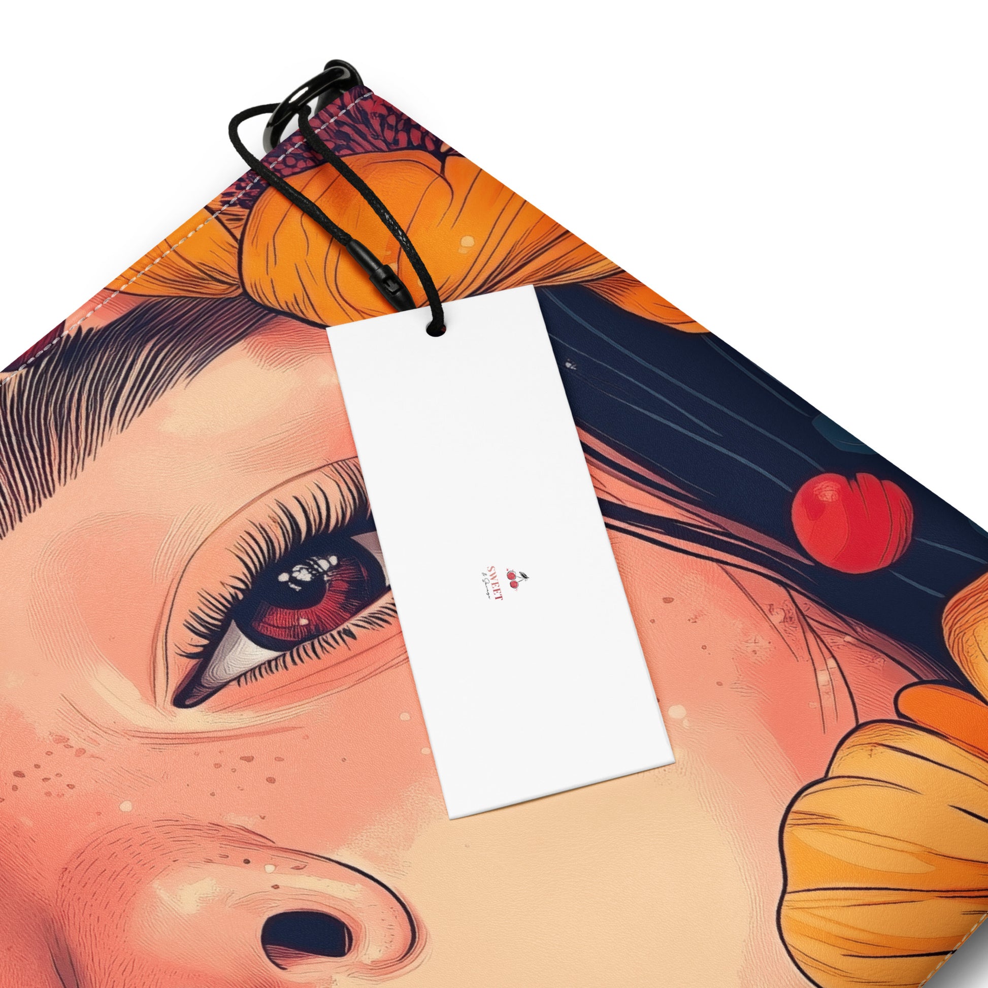 Close up of a crossbody bag with a colorful design of a woman's face and a cherry logo by Sweet and Savage on a white background. 
