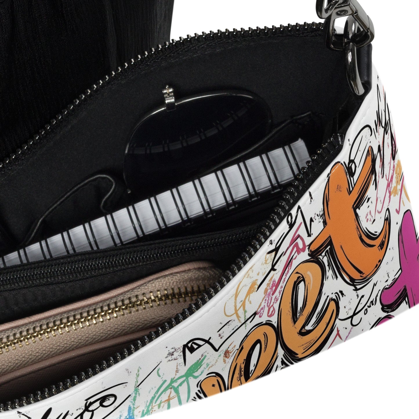 Close-up of a handbag with colorful graffiti-style text and designs on a white background.