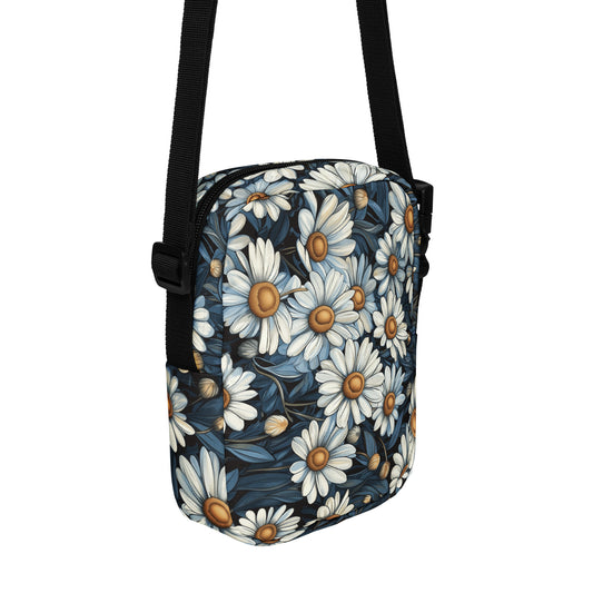 Crossbody bag daisy floral pattern with a black strap on a white background. 