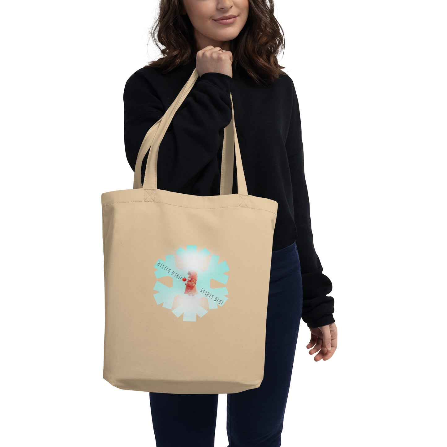 Eco-friendly organic cotton tote bag featuring a winter girl with a red apple inside a blue snowflake design, worn over the shoulder.