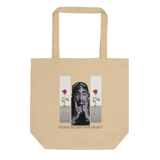 A beige canvas eco tote bag featuring a graphic print of Tupac Shakur with two red roses and the text 'THE ROSE THAT GROW FROM CONCRETE'.