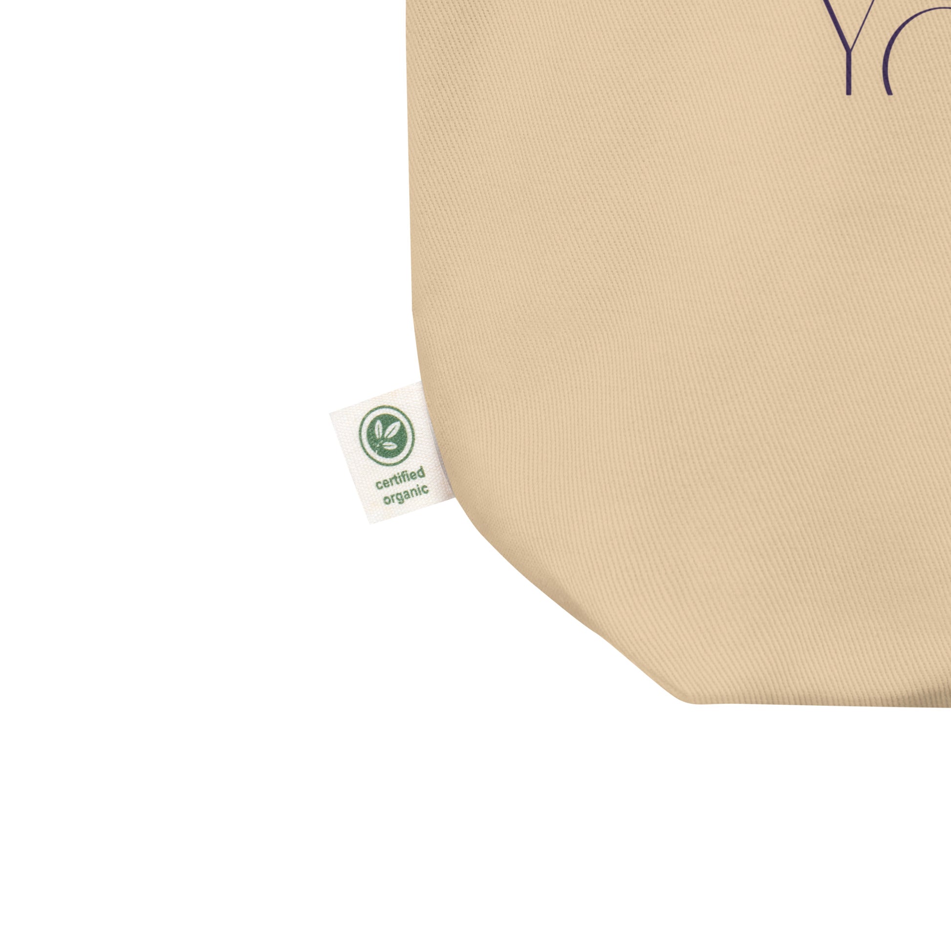 Beige tote bag with a green organic certification label on a white background