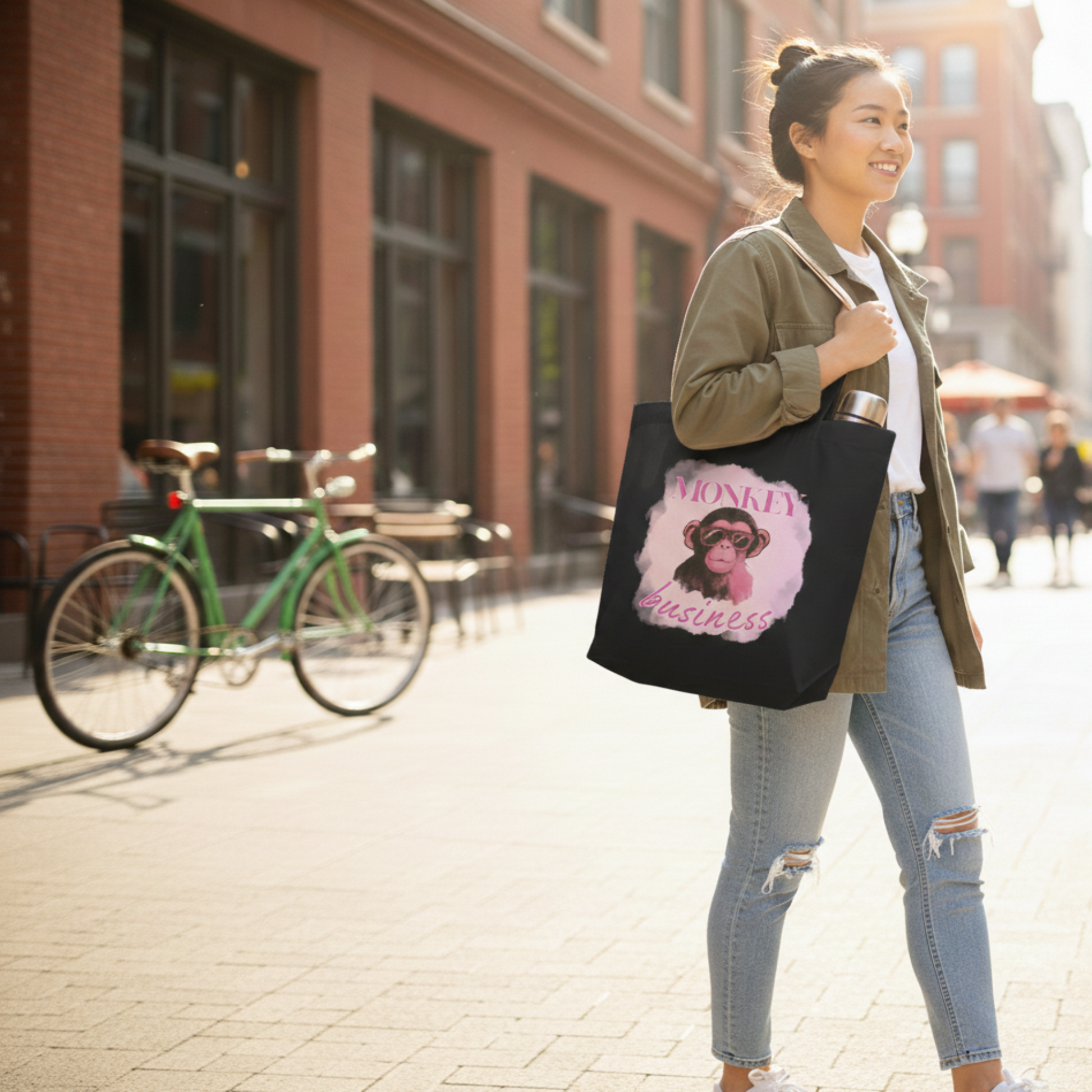 Lifestyle shot of a black eco-friendly tote bag with a graphic chimp and bubblegum design, styled in a city setting for the conscious shopper.