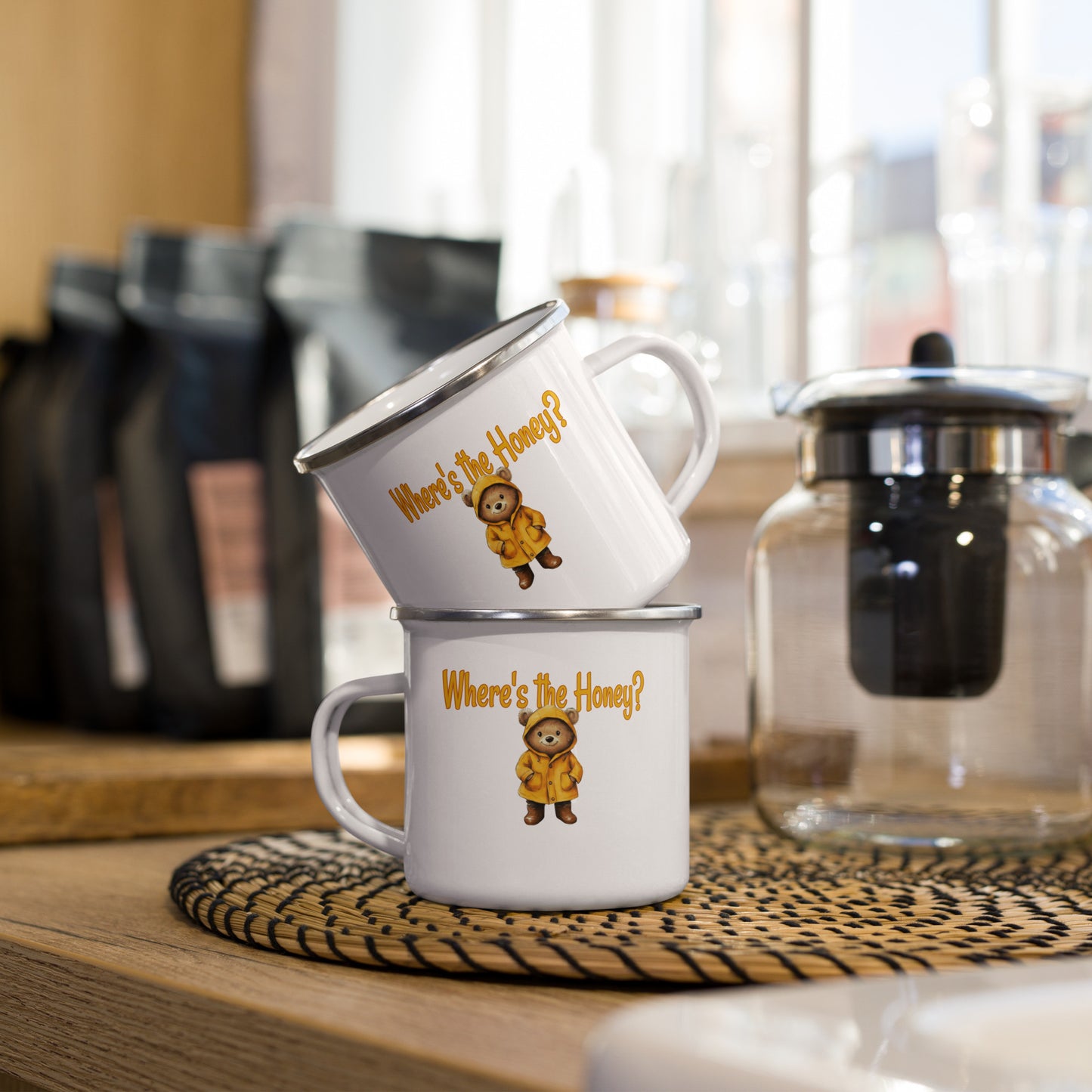 Two mugs stacked on a wooden surface with coffee-making equipment in the background.