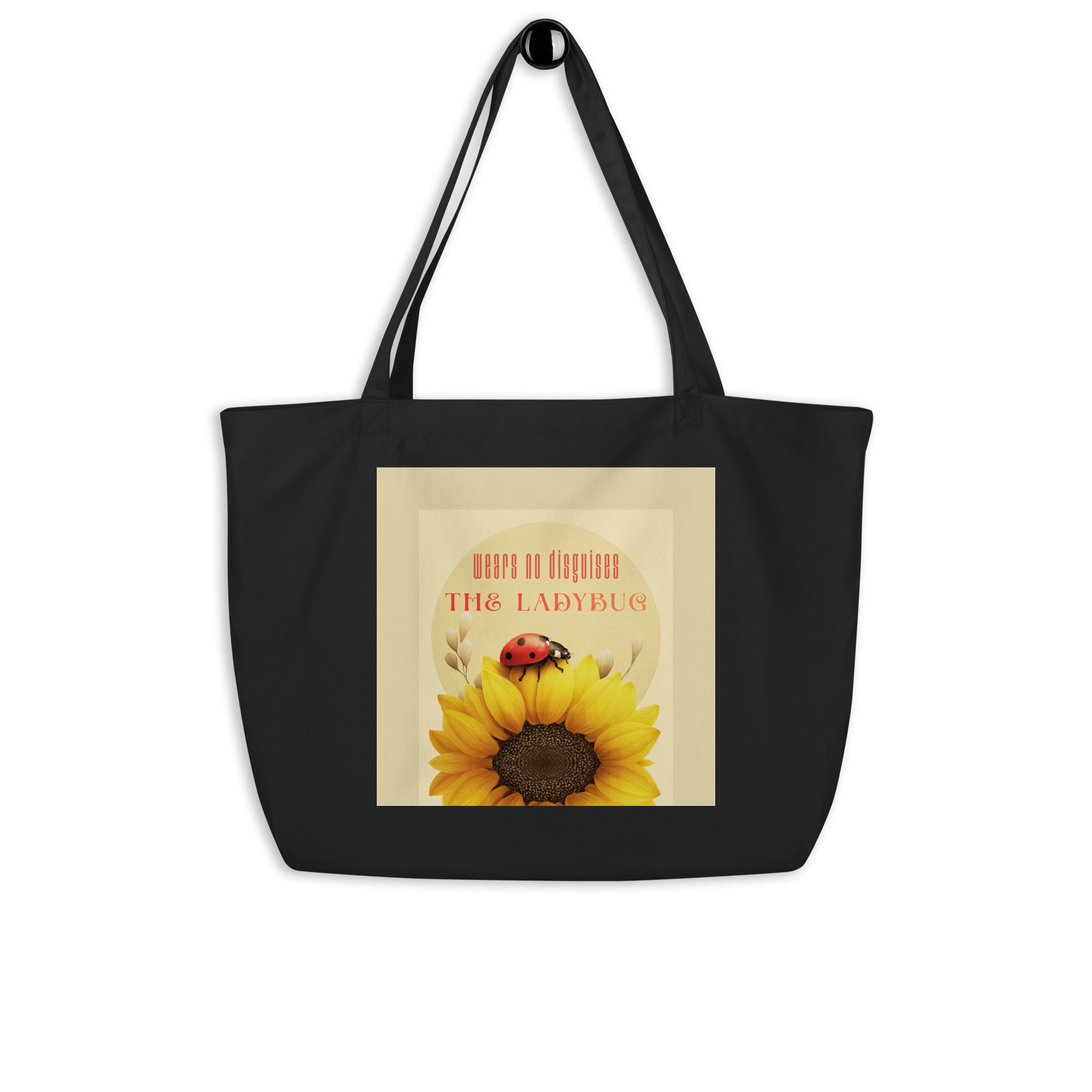 Black tote bag with a sunflower and ladybug design on a beige background