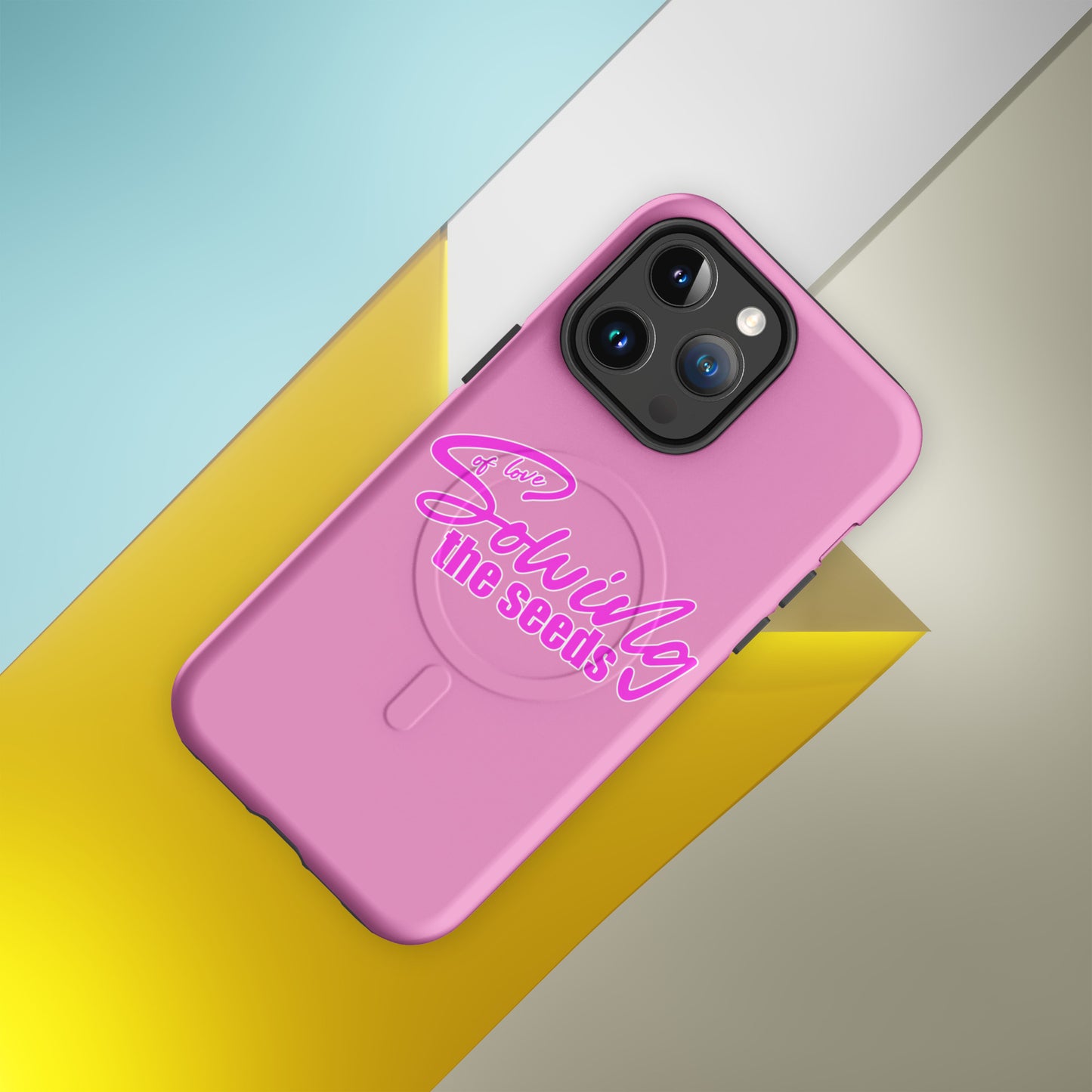 Vibrant pink MagSafe iPhone case featuring the Sowing the Seeds of Love circular emblem.