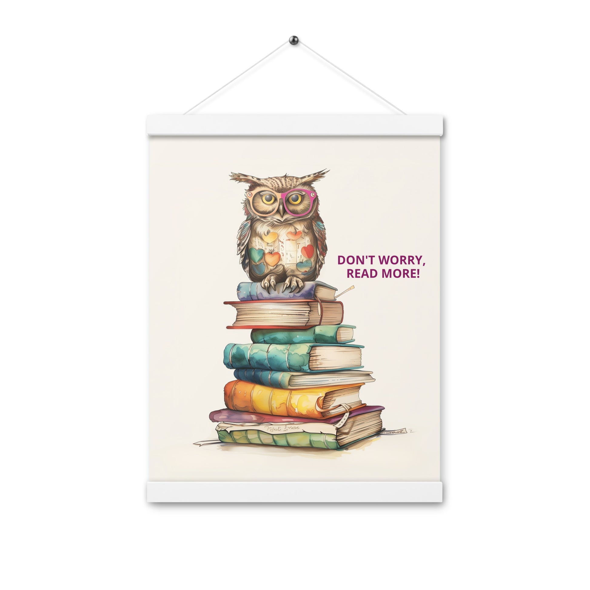 Whimsical illustration of an owl sitting on a tall stack of colorful books with the text "Don't Worry, Read More!". The poster is displayed with natural light-wood magnetic hangers and a hanging string.