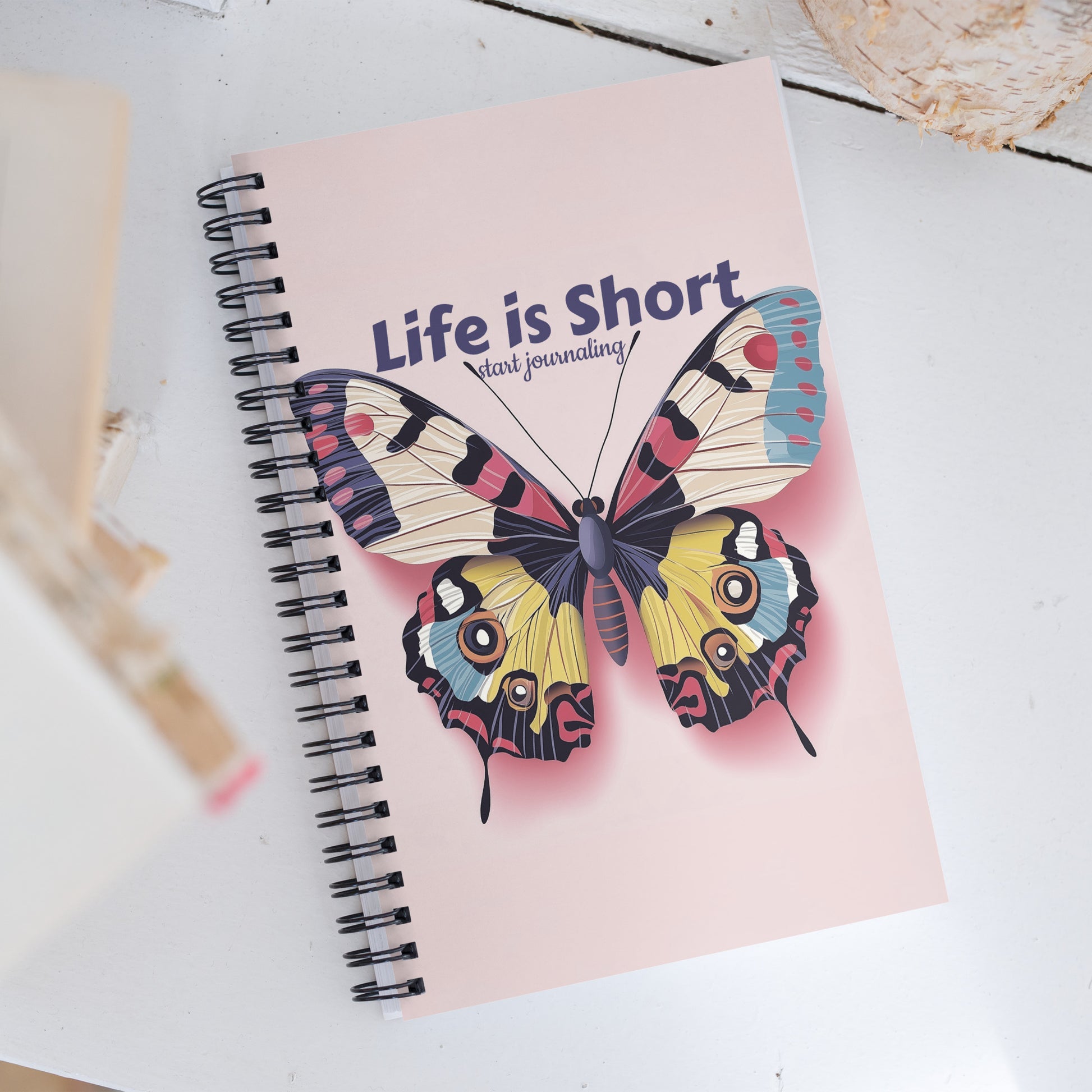 Spiral notebook featuring a vibrant pink butterfly design and the text "Life is Short, Start Journaling" by Sweet & Savage.