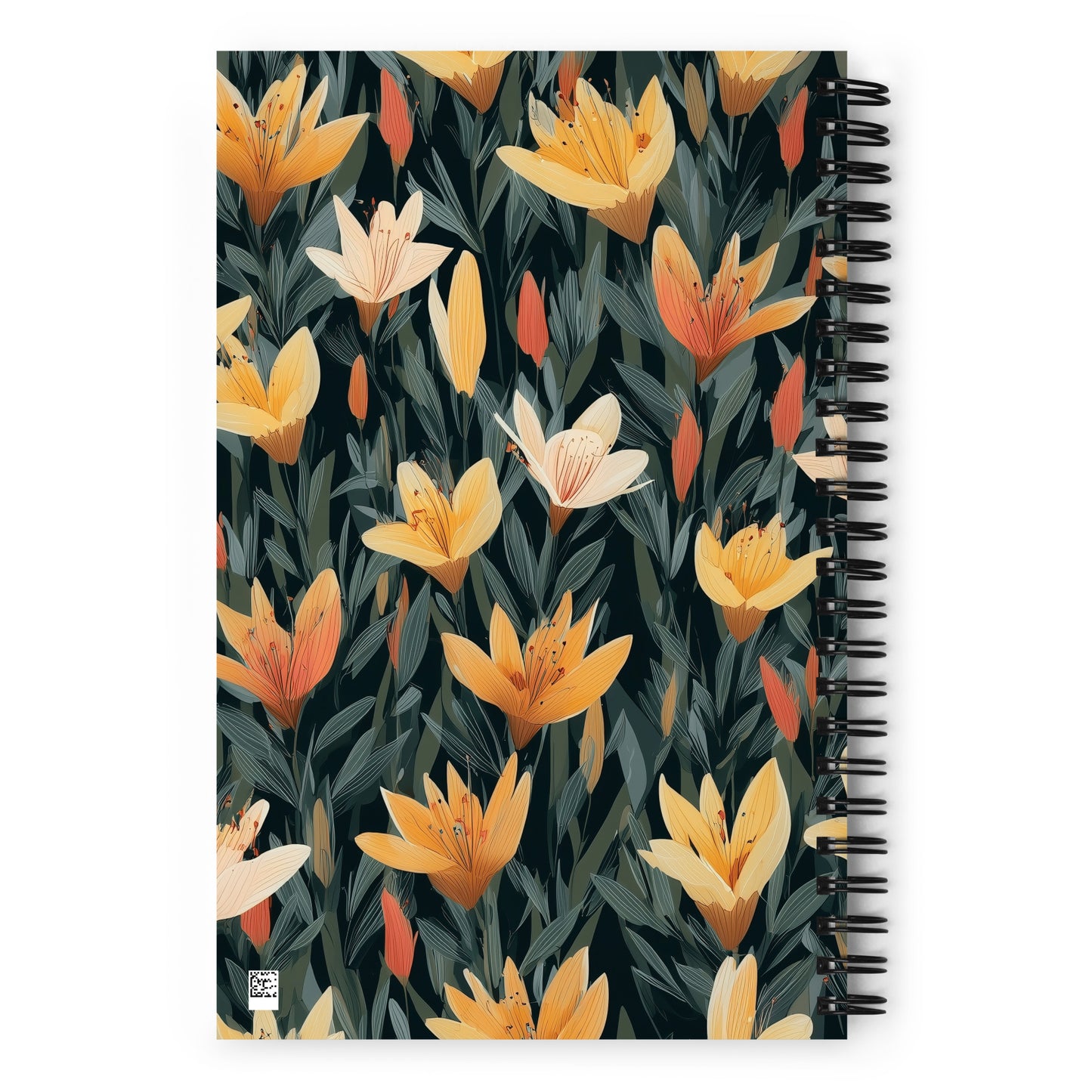 A5 spiral dotted notebook with a bold black and yellow tiger lily floral pattern on the cover, styled on a desk.