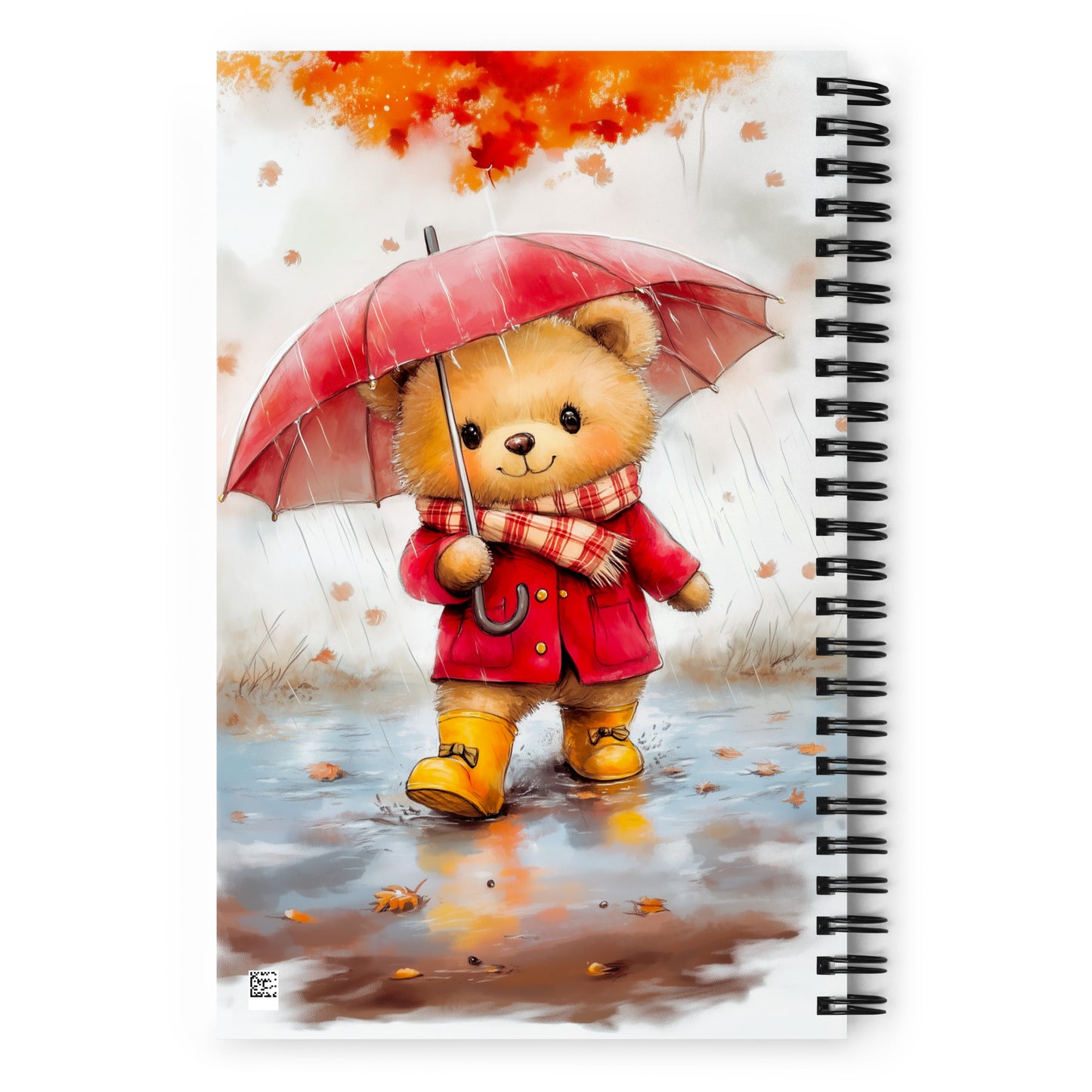 Spiral notebook with a teddy bear design holding a red umbrella and wearing a red coat and yellow boots, set against an autumnal background.