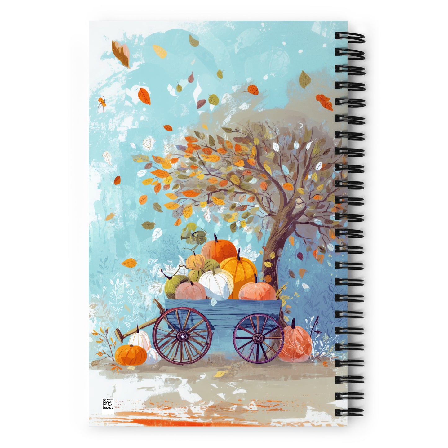 Back of a spiral notebook with an autumn design that features a wagon full of colorful pumpkins and falling leaves. 