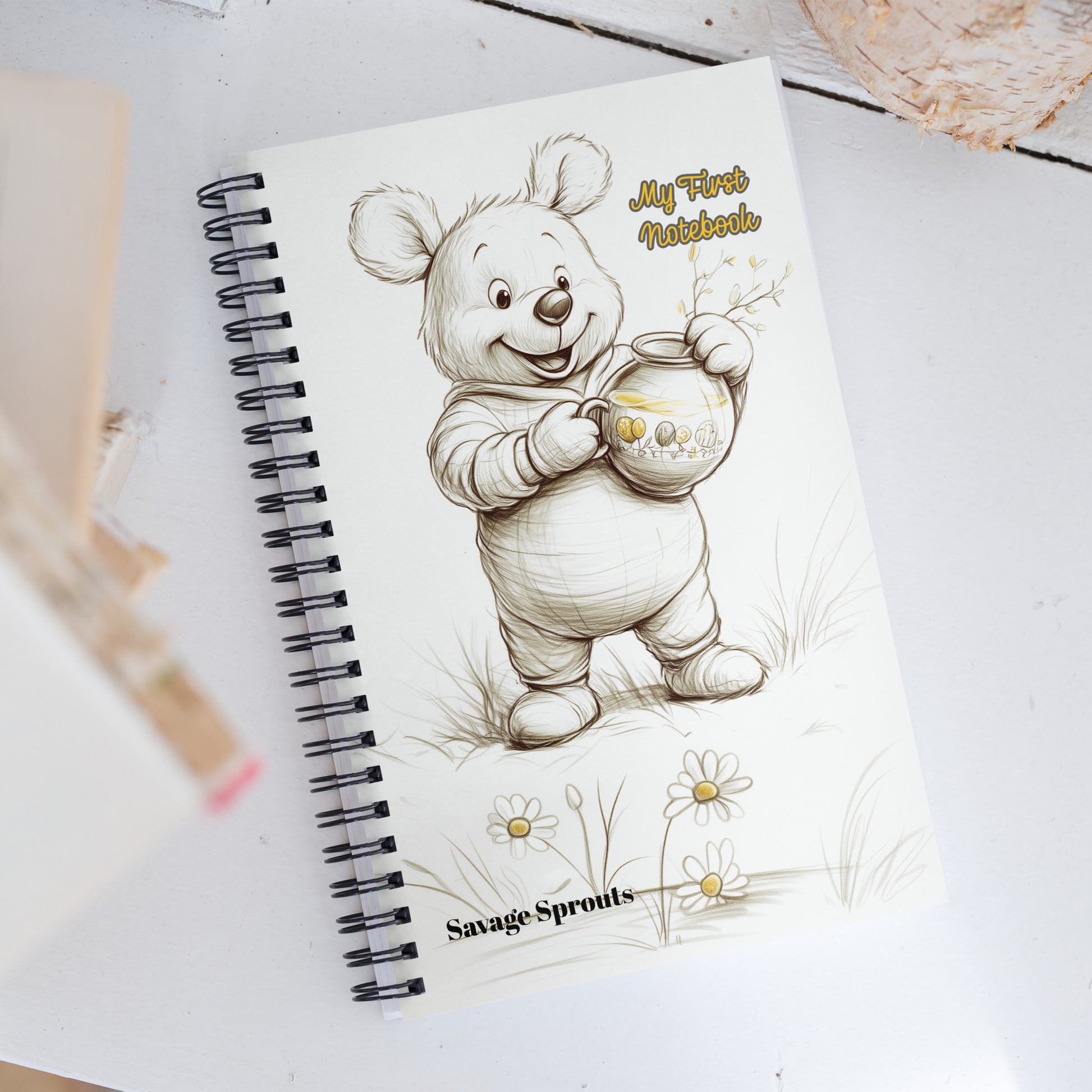 Notebook with a bear illustration and 'My First Notebook' text on a white surface.