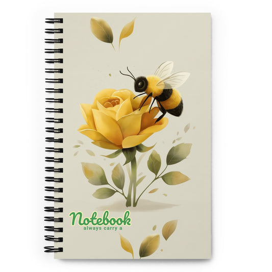 Spiral notebook with a design of a bee on a yellow rose with the text 'Always carry a notebook', on a white background.