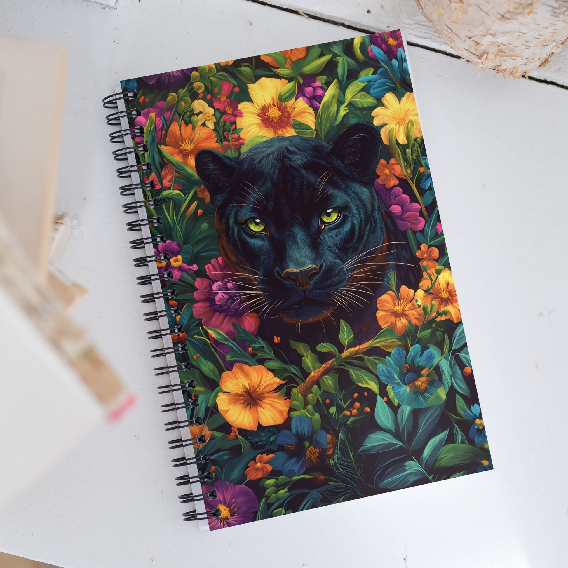 Spiral notebook with a black panther and floral design on a white surface by Sweet and Savage. 