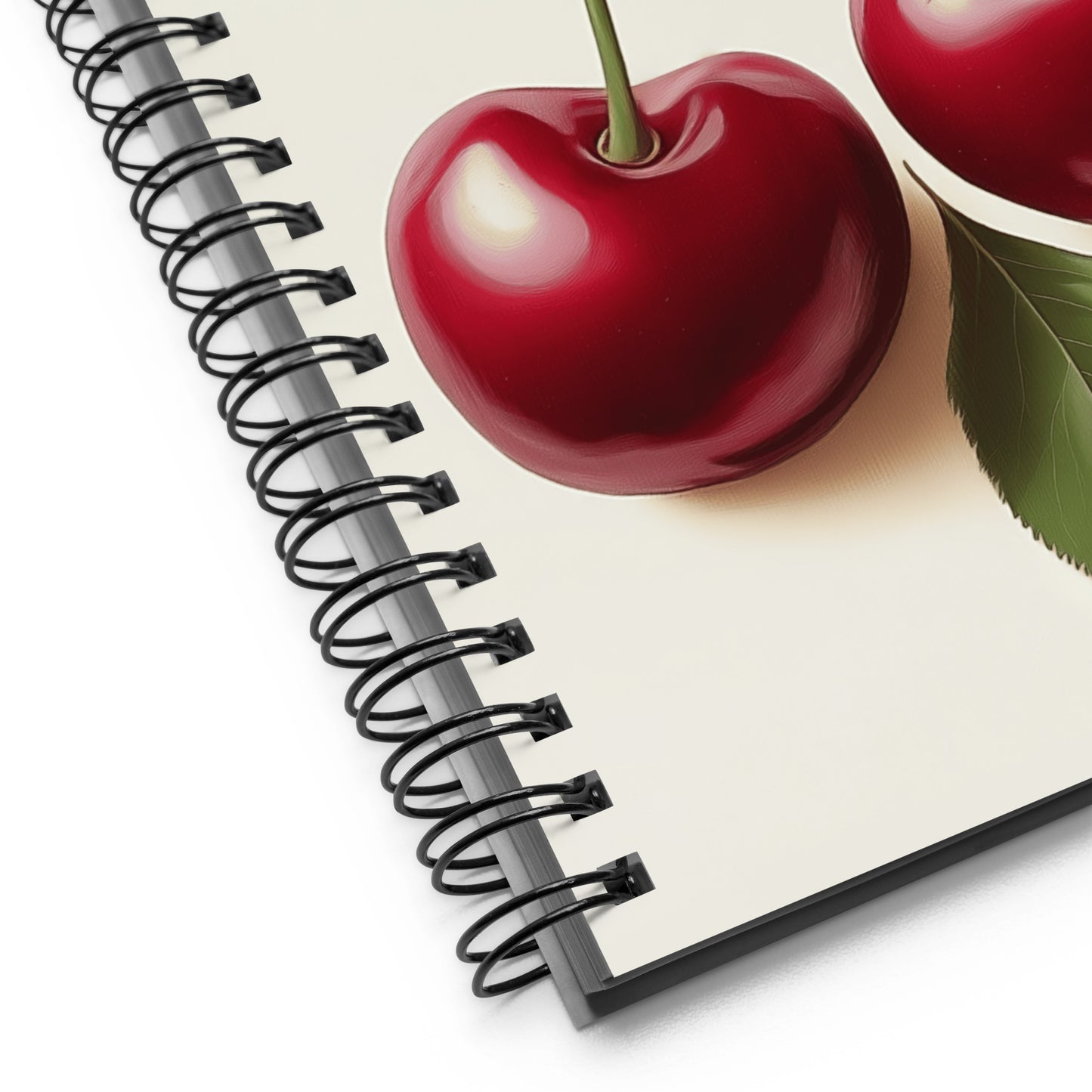 Red cherry on a spiral-bound notebook with a white background