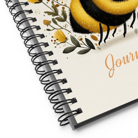 Spiral-bound notebook with a cute bee illustration on a white background. 