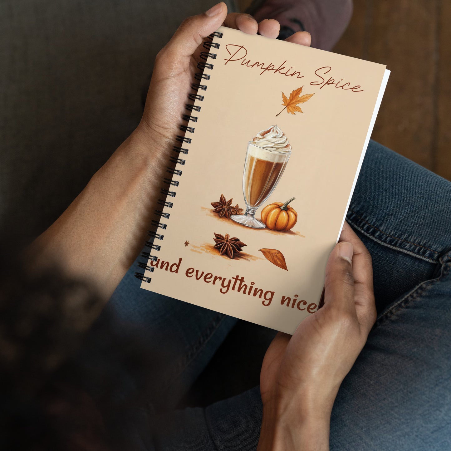 Spiral notebook with pumpkin spice design featuring a glass of pumpkin spice latte, pumpkins, and leaves on a beige background by Sweet and Savage. 