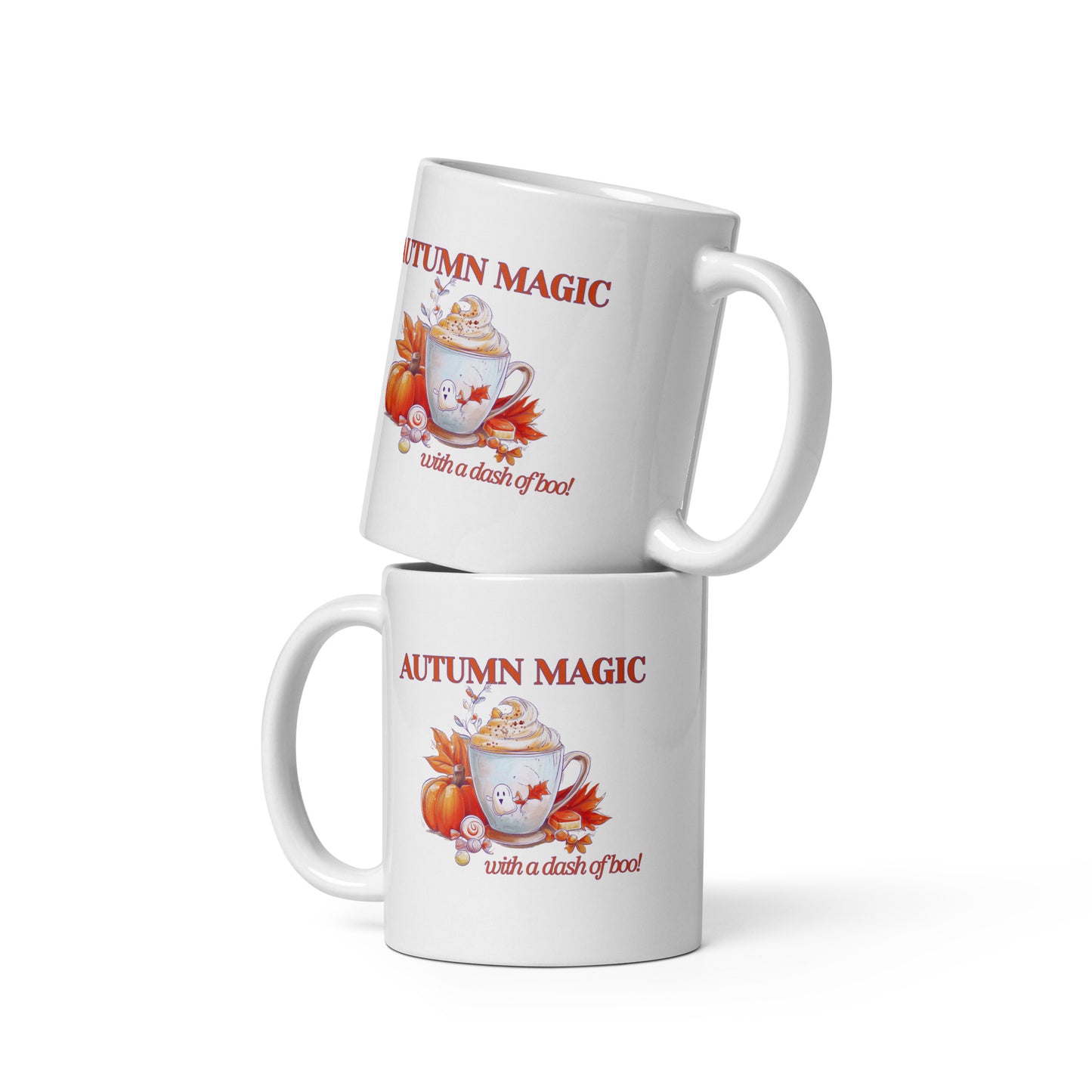 Two stacked white ceramic mugs with a fall-themed graphic that reads 'AUTUMN MAGIC with a dash of boo' in red text, featuring an illustration of a hot cocoa mug with autumn leaves and pumpkins.