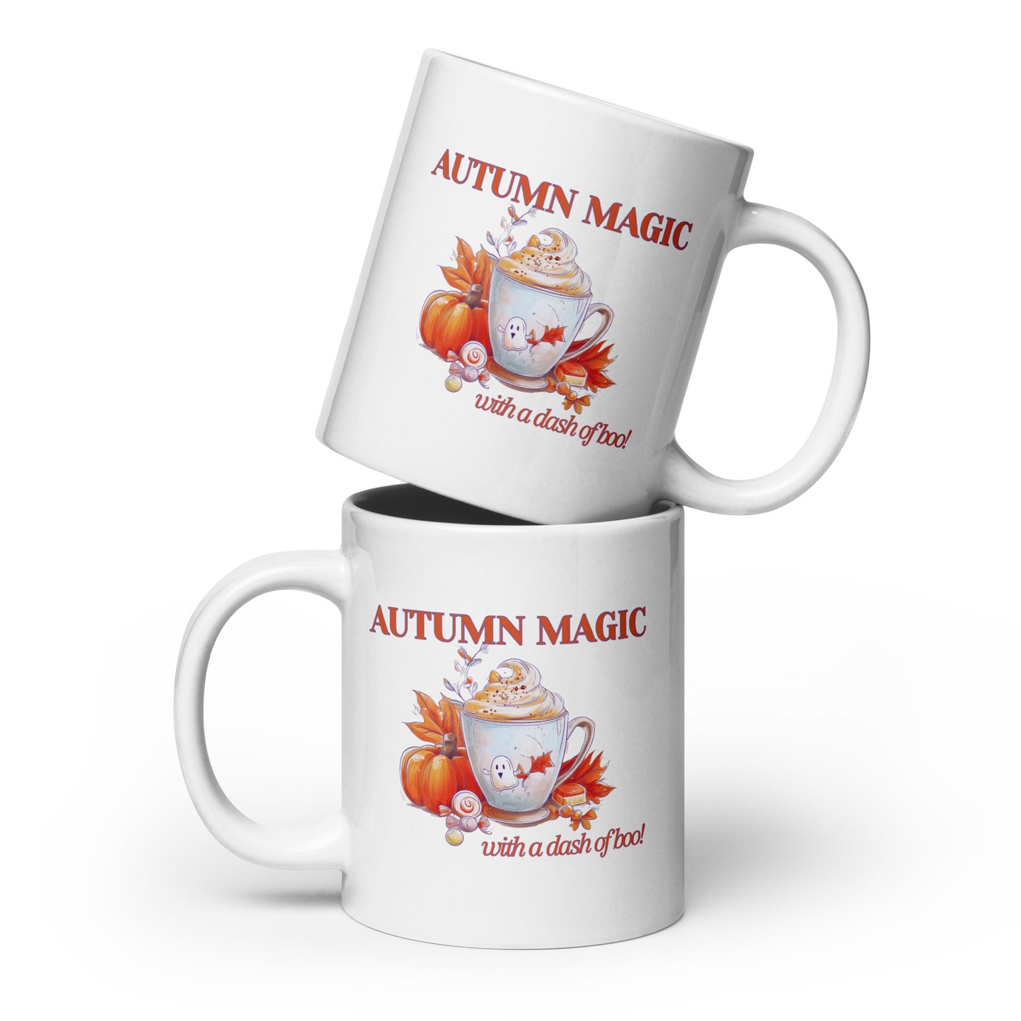 Two white ceramic mugs with a fall-themed graphic that reads 'AUTUMN MAGIC with a dash of boo.' The top mug is tilted above the bottom mug, which is upright.