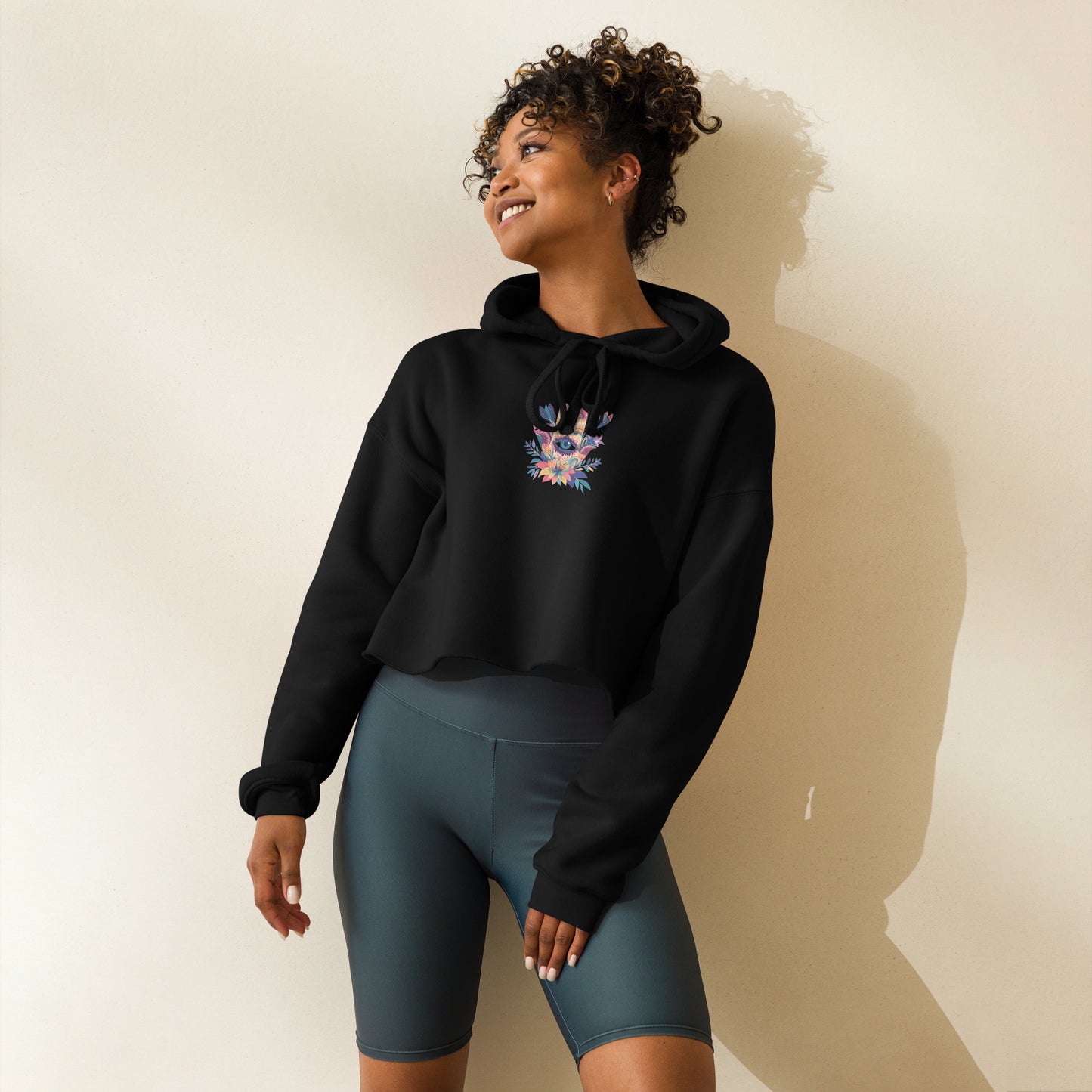 Woman wearing a black Sweet & Savage crop hoodie with a colorful graphic, sustainable airlume cotton fleece, made-to-order activewear.
